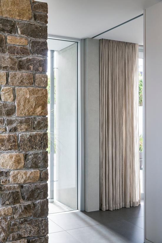 A textured curtain that blends well with the stone in this contemporary home