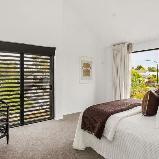 custom wood shutter in bedroom with bright white walls