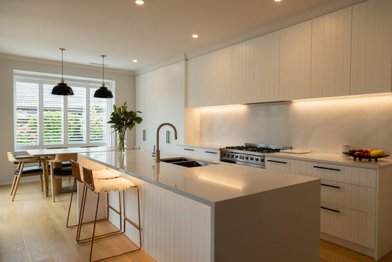 panelled kitchen in white with wood floor shutters