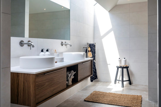 natural style bathroom with tiles and wood vanity with skylight