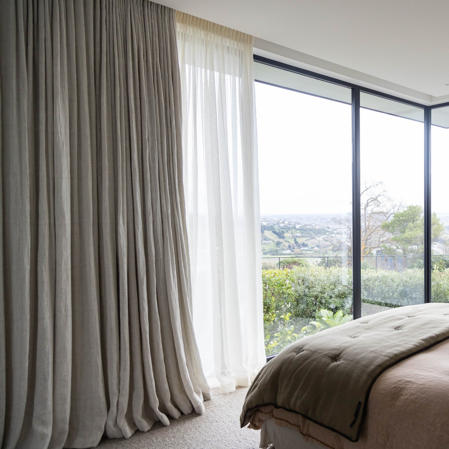 beautiful luxury curtains sheer and linen on large window in master bedroom. recessed tracks and new york pleat